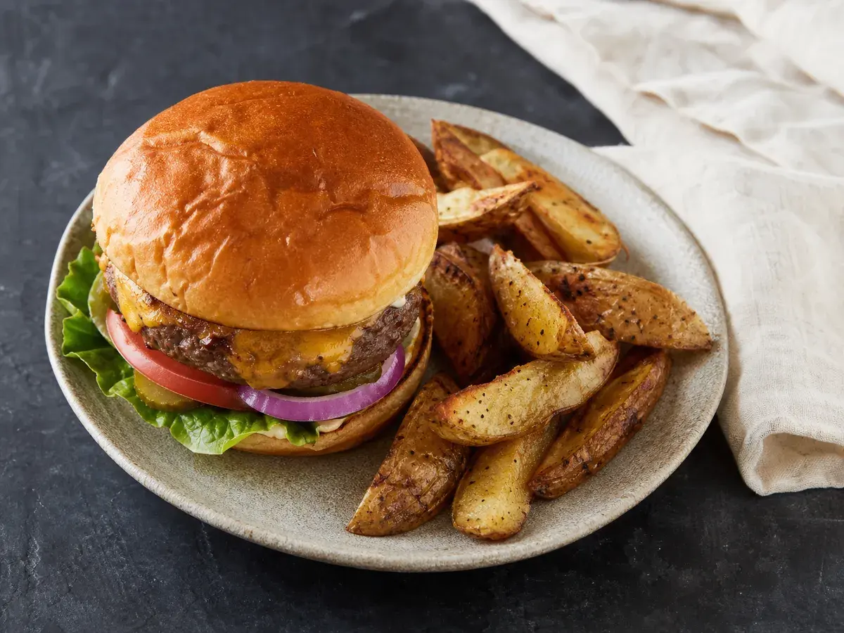 Illustrative image of burger with oven fries served in a simple everyday setting